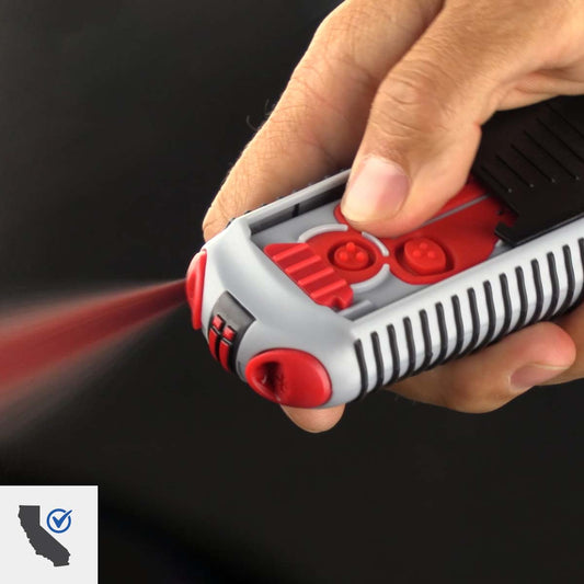 A hand pressed the firing button on the AIIRO. Red gel is bursting from the device. A badge on the image indicates California Compliance.