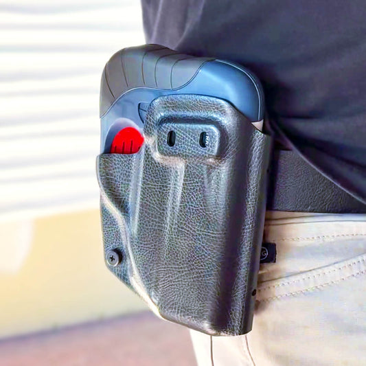 A close up of the HERO 2020 device in a holster being worn on someone's hip